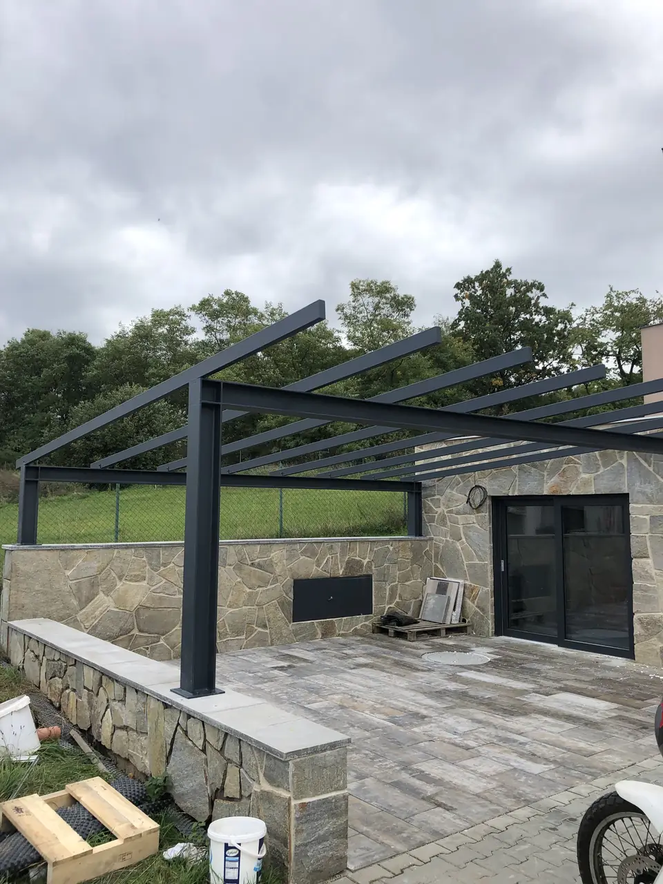 Pergola nad terasou s kamennou zídkou