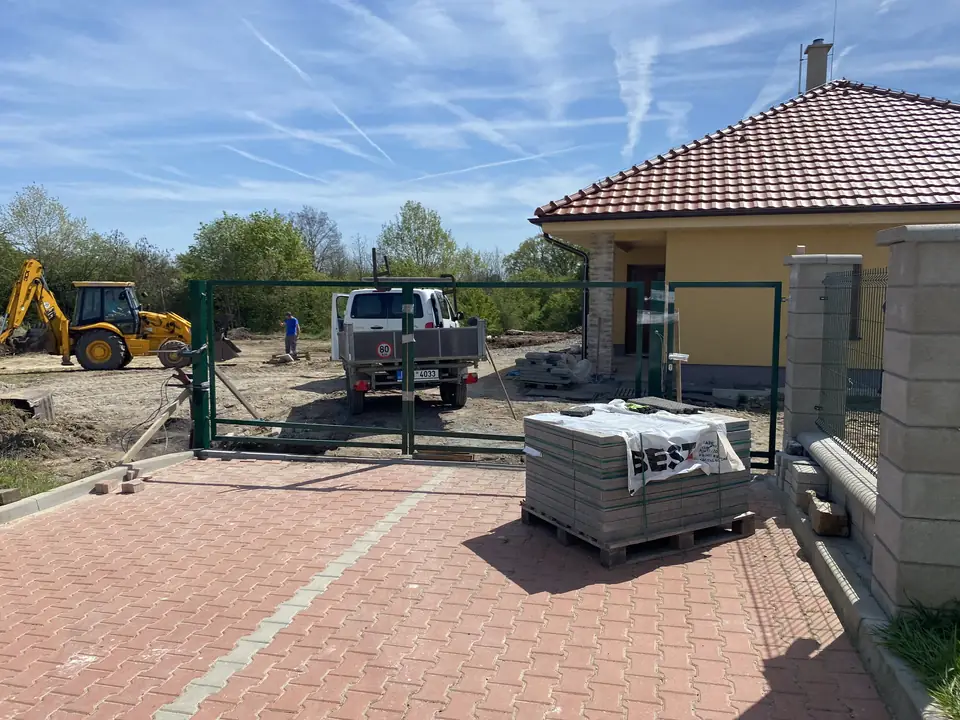 Osazování sloupku brány na rozestavěném pozemku
