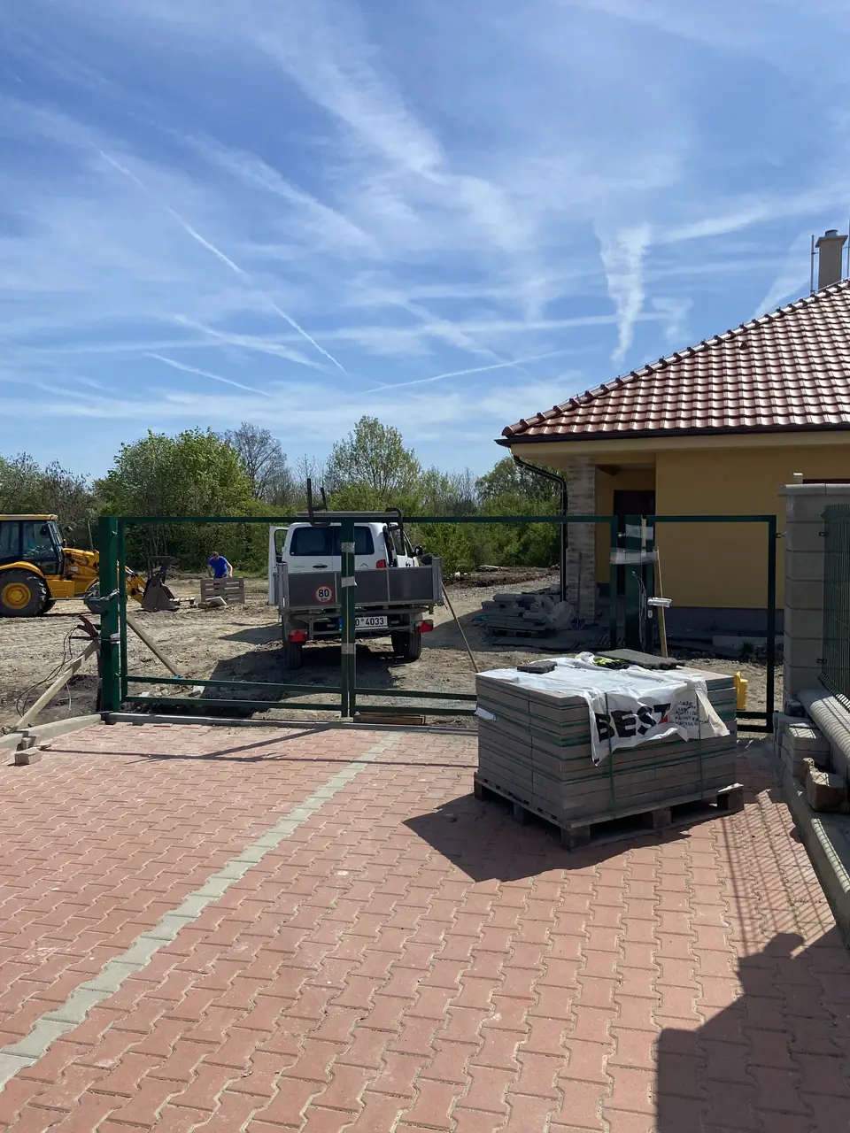 Rozestavěný vjezd s brankou u novostavby